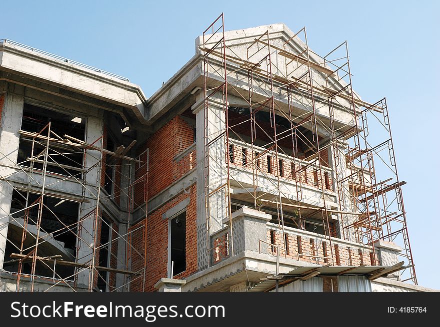 Construction of a new bungalow house site with scaffolding. Construction of a new bungalow house site with scaffolding