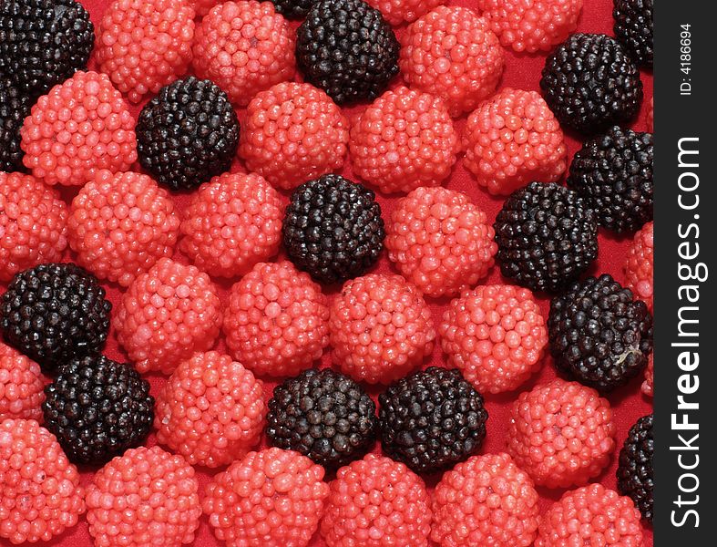 Sweets in the form of berries of a raspberry on a red background