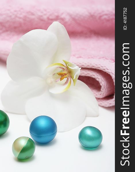 Orchid and bath oil pearls with pink towel. Orchid and bath oil pearls with pink towel.