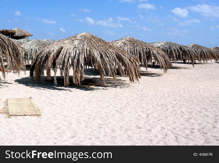 Palm umbrellas on the beach.