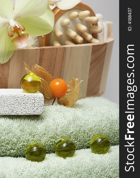 Accessories for a being relaxing wellness treatment with orchid on green towel. Accessories for a being relaxing wellness treatment with orchid on green towel.