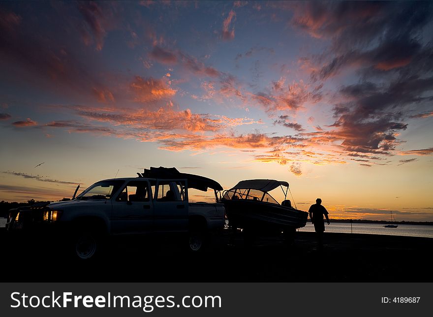 A fisherman prepares to launch his vessel at the dawn of a new day. A fisherman prepares to launch his vessel at the dawn of a new day