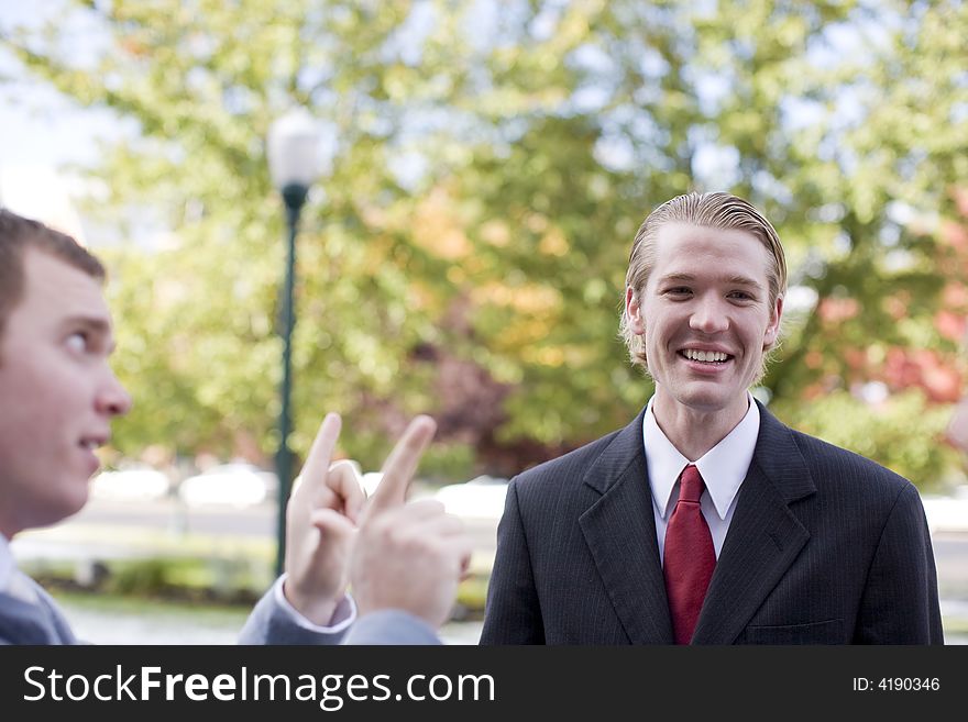 Side view of businessman talking with another businessman who is laughing. Side view of businessman talking with another businessman who is laughing