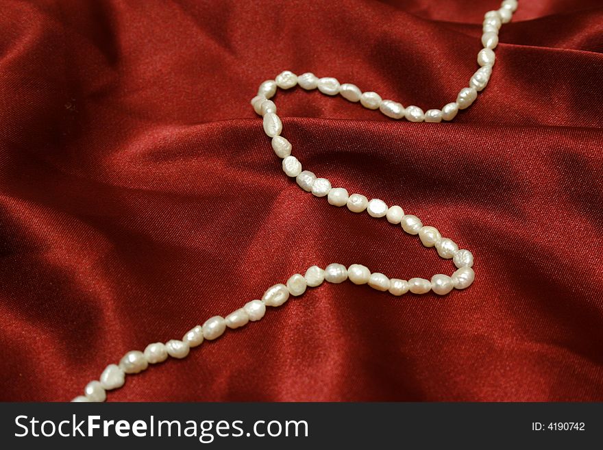 Beautiful pearls on red silk