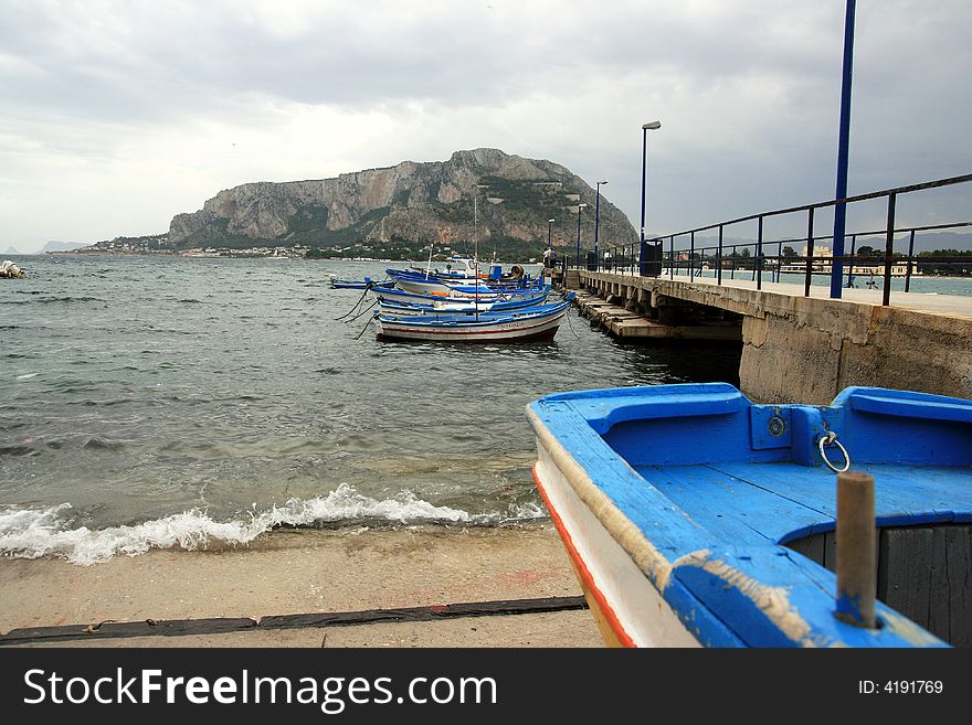 Colorful Sicilian boats on the dock in the port of Mondello, near Palermo. Coast line and beach. Sicily - Italy. Colorful Sicilian boats on the dock in the port of Mondello, near Palermo. Coast line and beach. Sicily - Italy