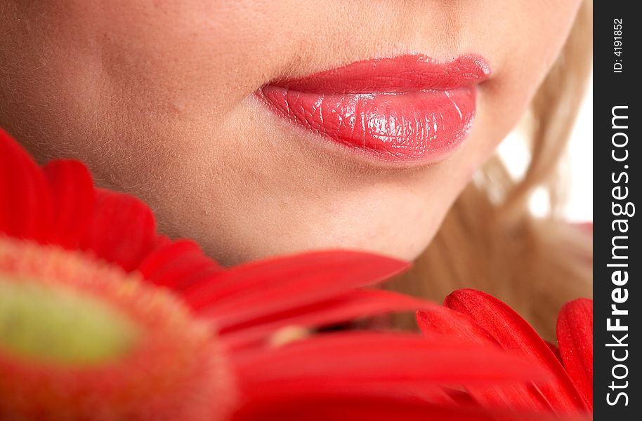 An image of woman's lips and flowers close-up. An image of woman's lips and flowers close-up