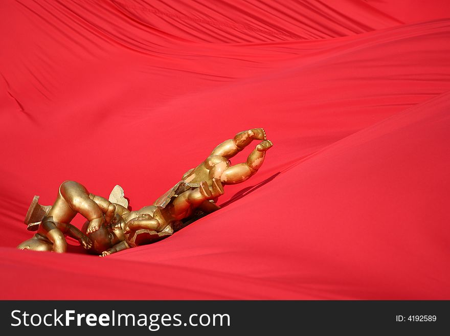 The image of gold angels on a red background. The image of gold angels on a red background