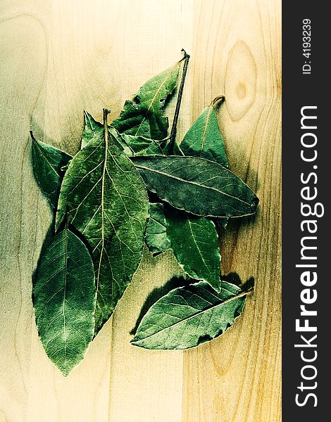 Green dry laurel leaves on wooden cutting board