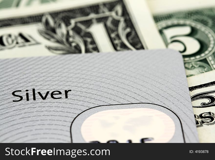 Silver credit card on dollar bills. Silver credit card on dollar bills