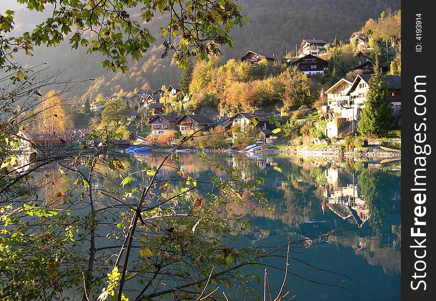 A group of houses perfectly reflect on a river. A group of houses perfectly reflect on a river