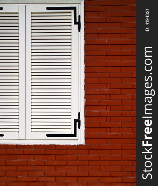 Chromatic composition based on the contrast of a closed white window on red bricks. Chromatic composition based on the contrast of a closed white window on red bricks