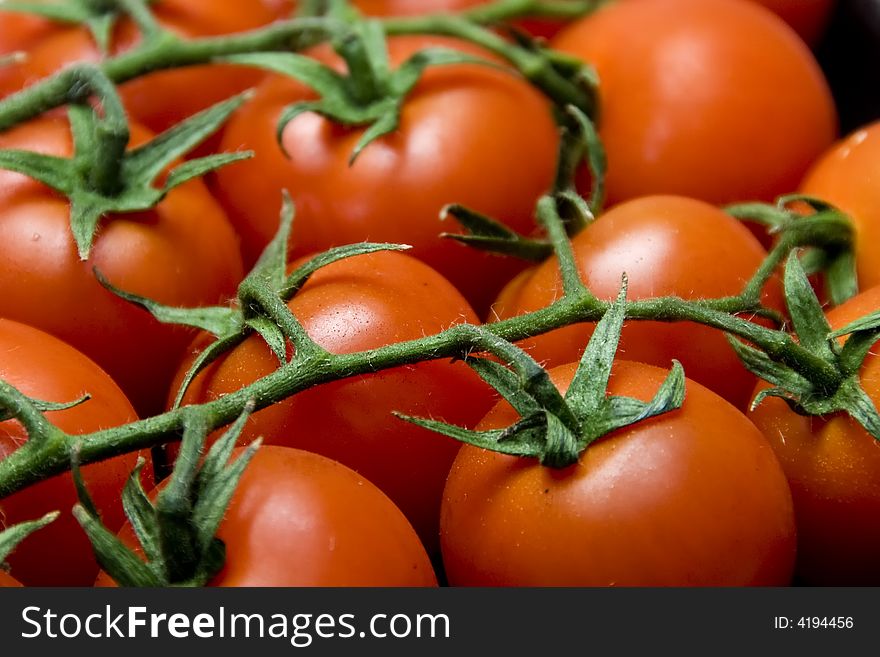 Closeup of red tomatoes with green stems. Closeup of red tomatoes with green stems