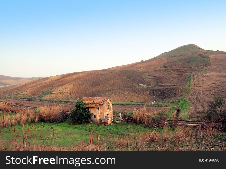 Old country train station,  Autumnal landscape.  Land, hills and  blue sky. Sicily, Italy