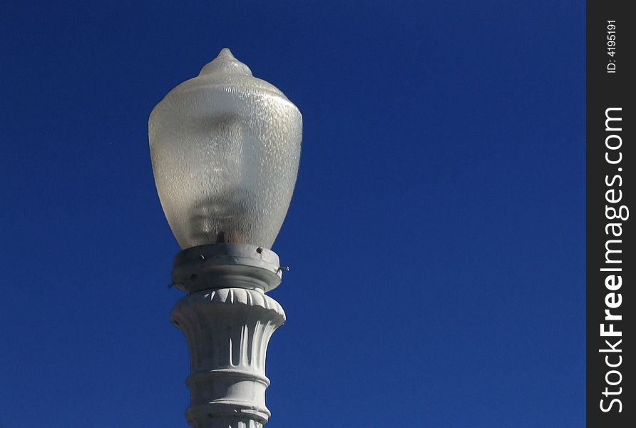 White lamp against a deep blue sky. White lamp against a deep blue sky