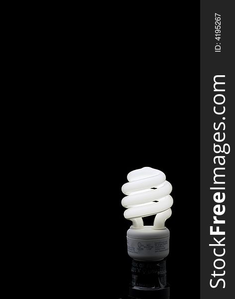 Compact Fluorescent bulb against a black backround with plenty of space for type. Compact Fluorescent bulb against a black backround with plenty of space for type.