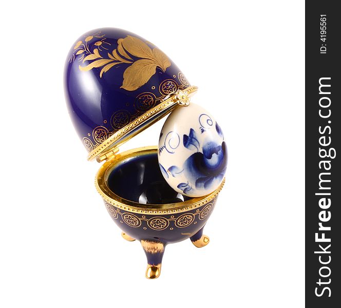 Dark blue easter egg in a gold small box on a white background