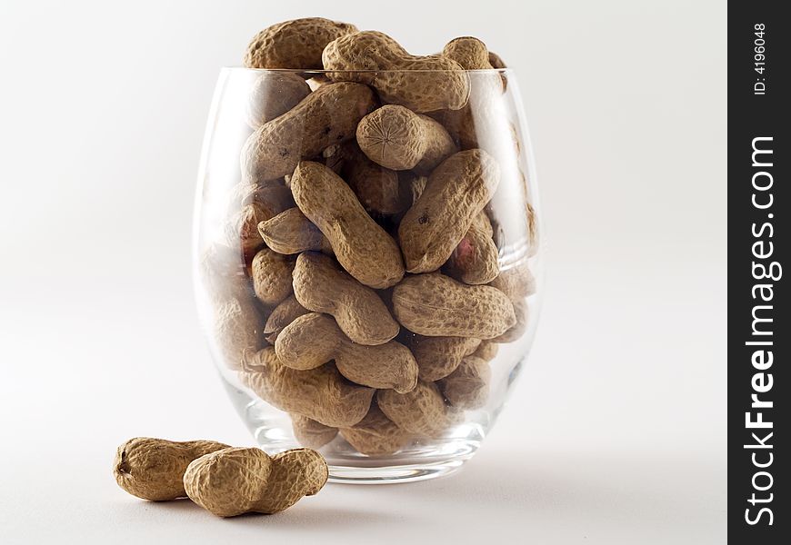 Glass of peanuts isolated on white background