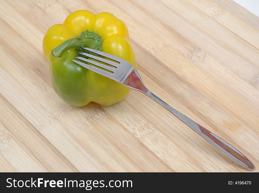 A capsicum and a fork on the floor. A capsicum and a fork on the floor
