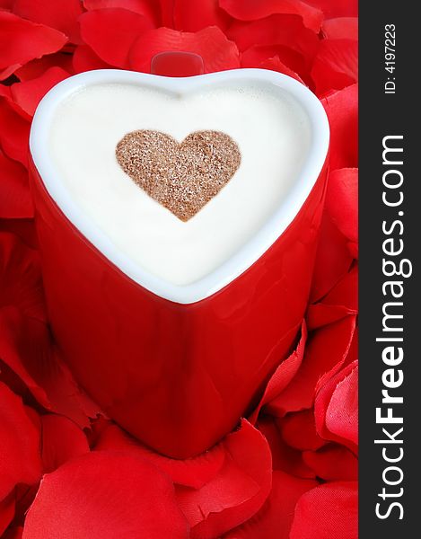 Heart shaped coffee cup on a bed of rose petals