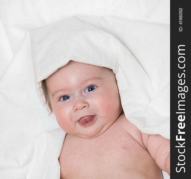 Small smiling baby on bed