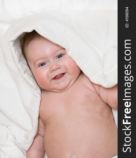 Small smiling baby on bed