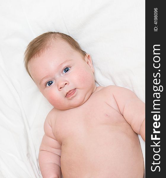 Small smiling baby on bed