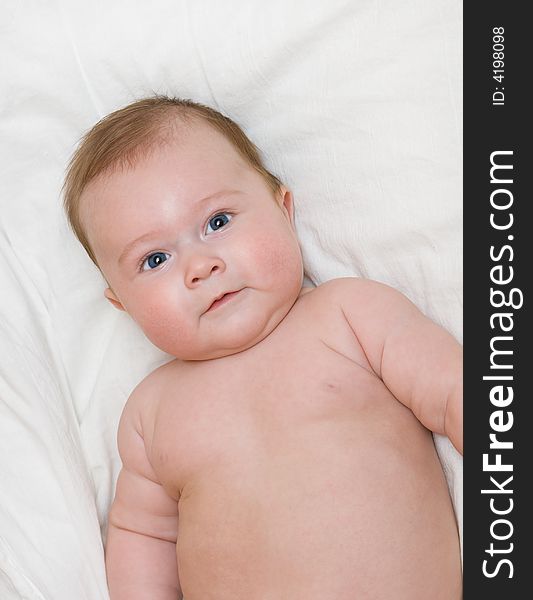 Small smiling baby on bed