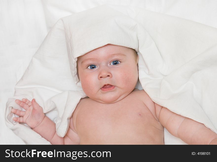 Small smiling baby on bed