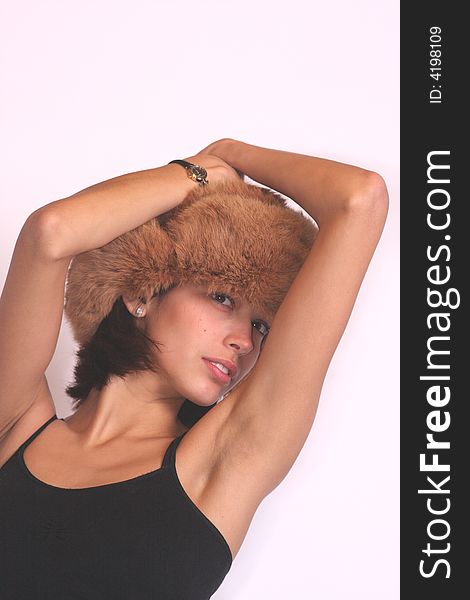 Young woman with a fur hat posing in a seductive manner. Young woman with a fur hat posing in a seductive manner