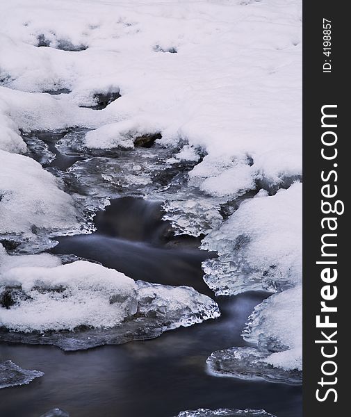 Long exposure image of a cold brook in winter. Long exposure image of a cold brook in winter.