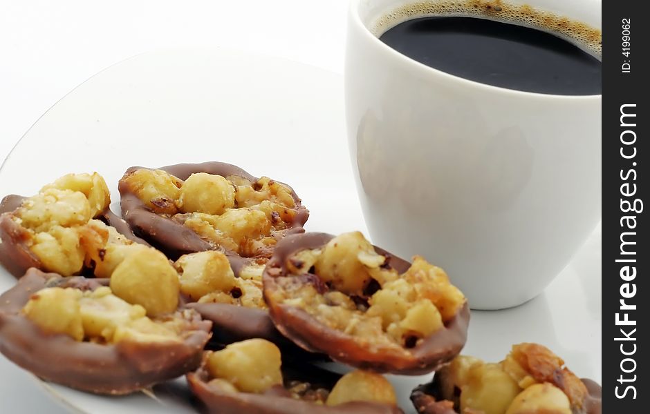 Cup of black coffee with chocolate nuts cake on white plate. Cup of black coffee with chocolate nuts cake on white plate