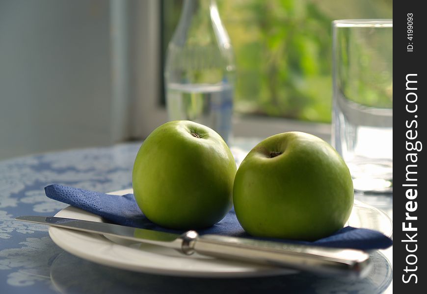 Backlit apples on plate in fromnt of sunlit window. Backlit apples on plate in fromnt of sunlit window