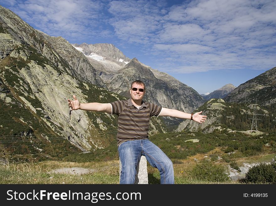 Happy man sitting beside mountains. Happy man sitting beside mountains