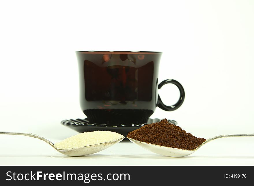 Two  tea-spoon with coffee and sugar infront of coffee-cup. Two  tea-spoon with coffee and sugar infront of coffee-cup
