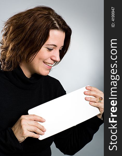 Nice woman has an empty white card in her hand and smiling and looking to it. Nice woman has an empty white card in her hand and smiling and looking to it.