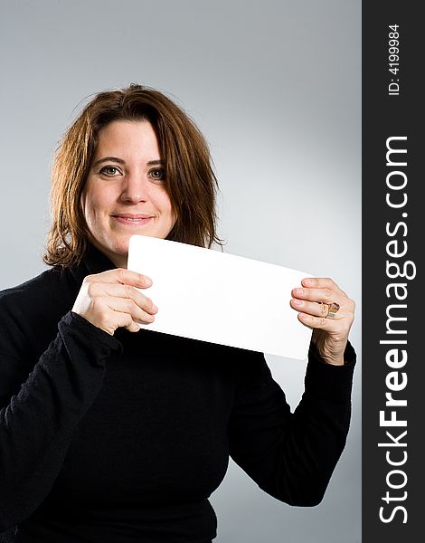 Woman keeping a white empty card up with both hands. Woman keeping a white empty card up with both hands.