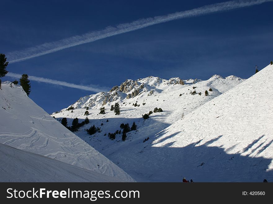 In Les Arcs, France, snowy mountains and bluen skies, crossed by geometric vapour trails. In Les Arcs, France, snowy mountains and bluen skies, crossed by geometric vapour trails.
