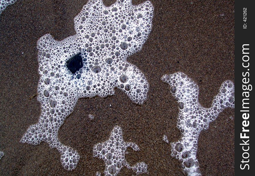 Sea foam on a sandy beach