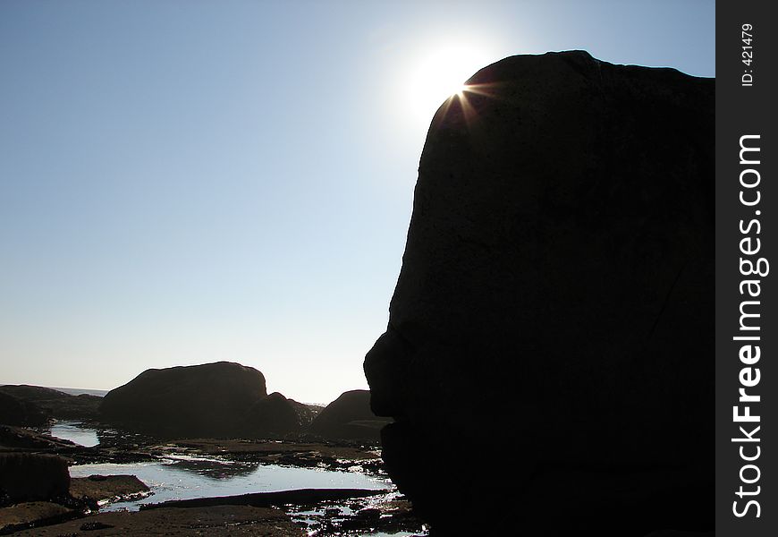 Big sea rock hiding the sun. Big sea rock hiding the sun