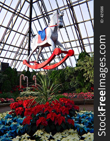 An indoor display of poinsettias and holiday objects. An indoor display of poinsettias and holiday objects.