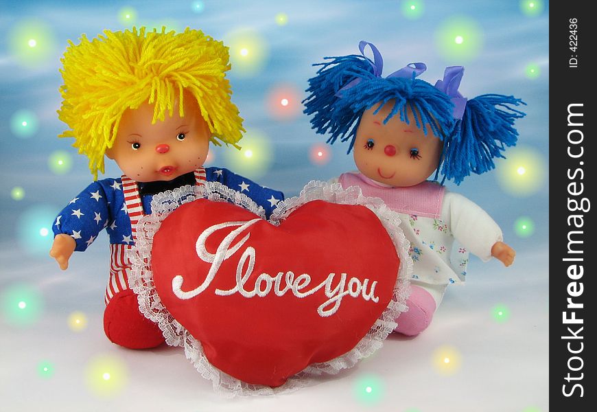 Two dolls: boy and girl with red heart on colurful background. Two dolls: boy and girl with red heart on colurful background.