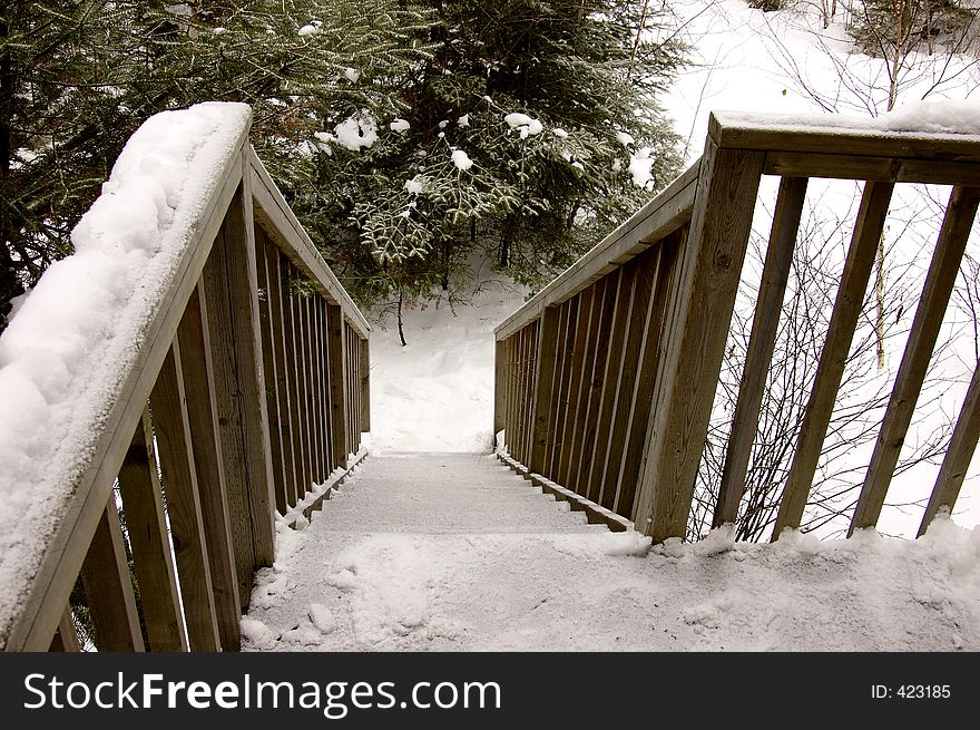 A set of steep wooden stairs covered in snow. A set of steep wooden stairs covered in snow