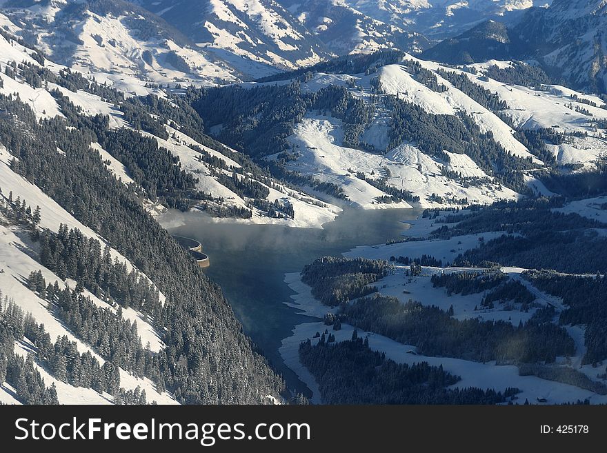 Altitude lake in the Alps with a dam for electricity production. Altitude lake in the Alps with a dam for electricity production.