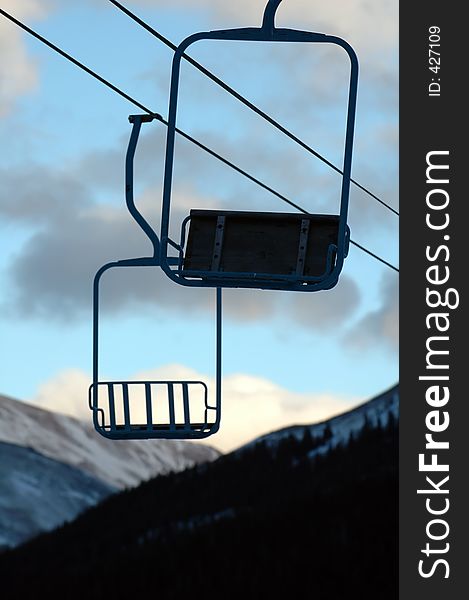 A chair lift makes the last trip back from the mountain empty. A chair lift makes the last trip back from the mountain empty.