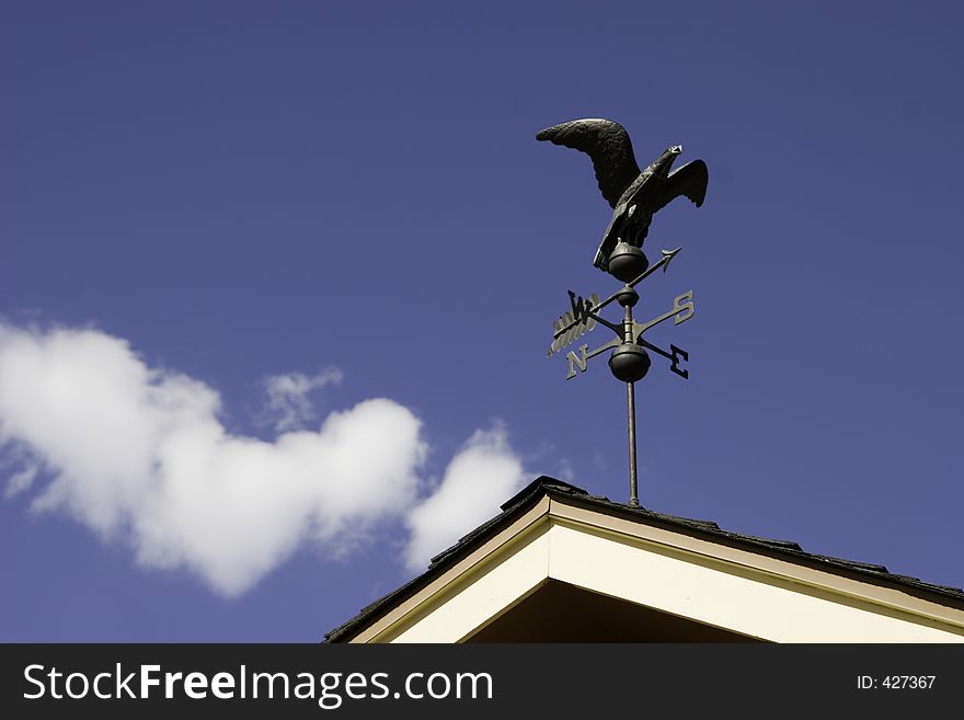 Beautiful weather overlooks an American Eagle weather vane pointing south. Beautiful weather overlooks an American Eagle weather vane pointing south.