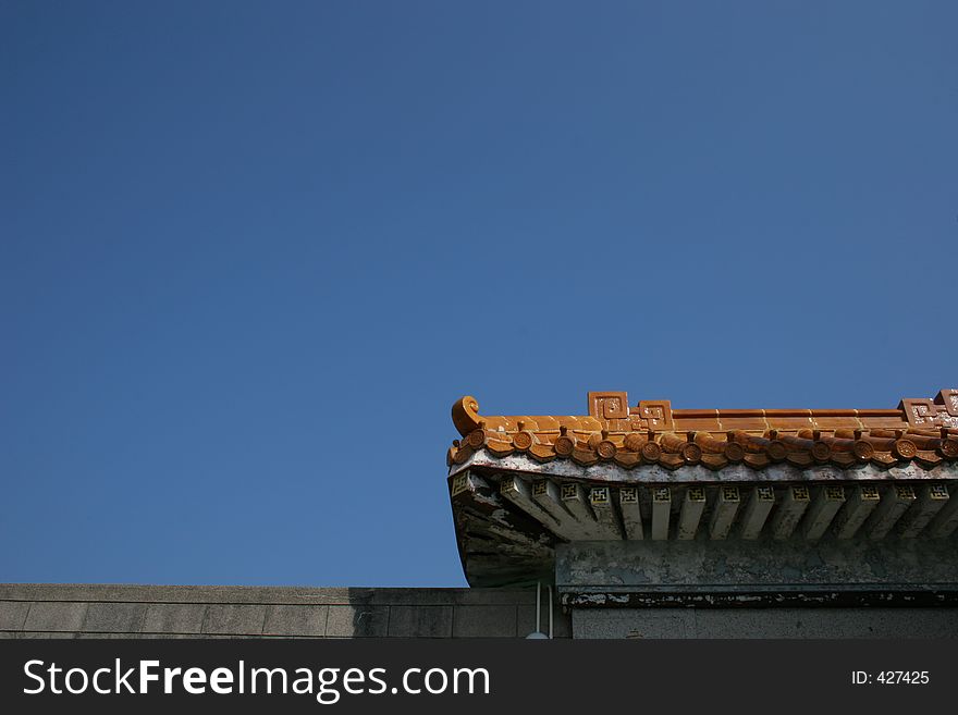 Chinese style roof decoration at gate of mansion, with expanse of sky for text or other purposes. Chinese style roof decoration at gate of mansion, with expanse of sky for text or other purposes.
