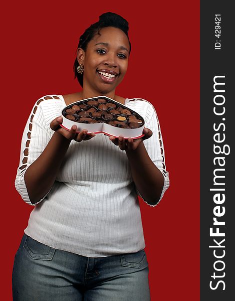 A pretty young woman holding a box of valentine candy.