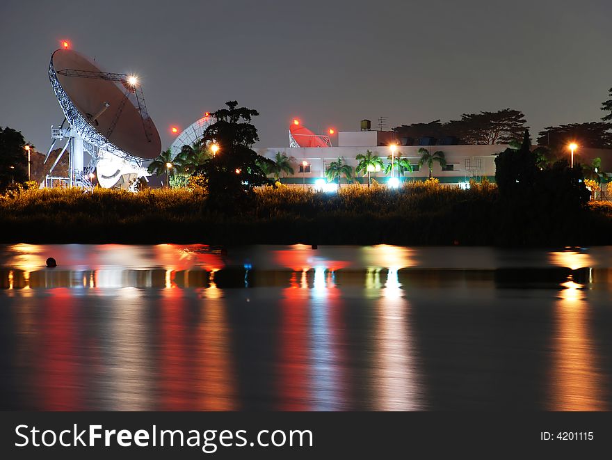 A Satellite Earth Receiving Station seen at night and reflected in a lake. A Satellite Earth Receiving Station seen at night and reflected in a lake