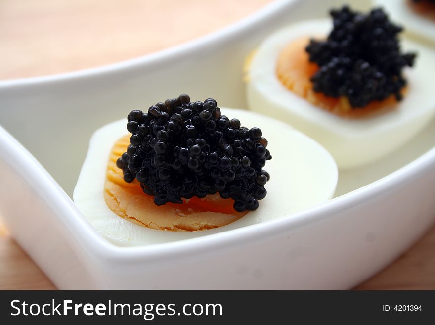 Closeup of a boiled egg with black caviar topping. Closeup of a boiled egg with black caviar topping.