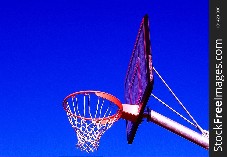 Basket ball net and ring from the side against blue sky. Basket ball net and ring from the side against blue sky